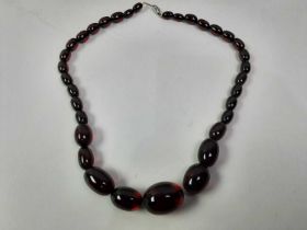 STRING OF CHERRY AMBER-TYPE OVAL BEADS, EARLY 20TH CENTURY