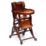 A late Victorian stained beech wingback child's high chair, fully adjustable, on iron wheels, 83cm h
