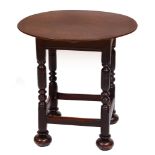 An oak table, 19th c, the round top on square frame and turned legs with stretchers and bun feet,