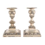 A pair of Victorian silver dwarf candlesticks,  in neo classical style, on beaded square foot,