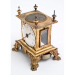 A gilt brass table clock, 19th c and earlier, with silver, possibly champleve, dial to the top of