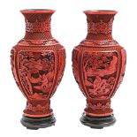 A pair of Chinese cinnabar lacquer vases, c1900, carved with four panels of immortals and other