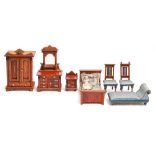 A suite of German stained softwood doll's house furniture, late 19th c, comprising wardrobe, bed,