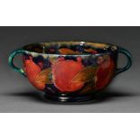 A Moorcroft Pomegranate bowl, c1920, with loop handles, 21cm over handles, impressed mark, green