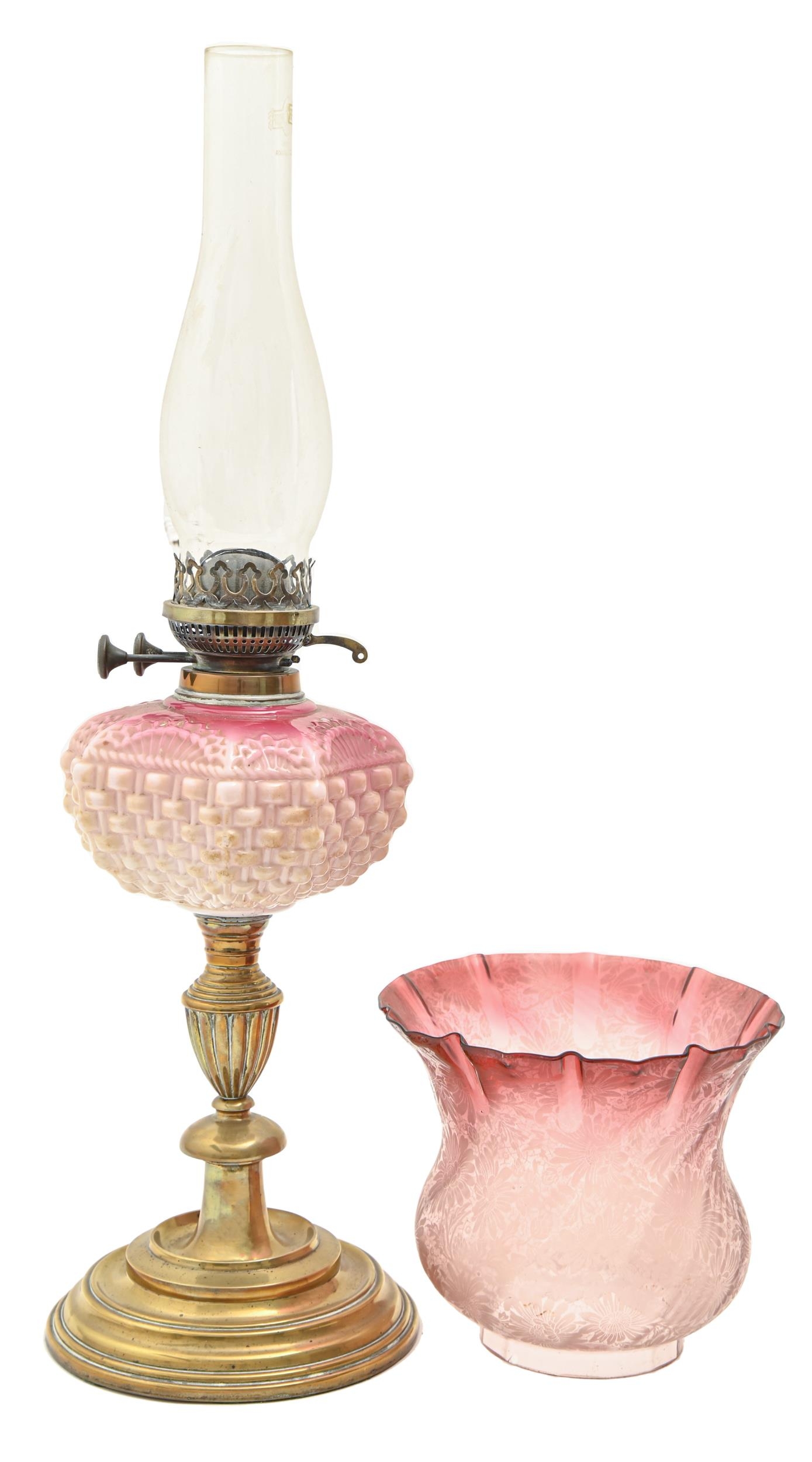 A Victorian brass oil lamp, with shaded pink moulded glass fount of cut cornered square form,