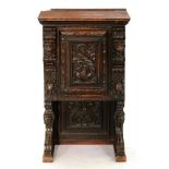 A Northern European oak cupboard, c1870, the door with carved panel of a fanciful long tailed bird