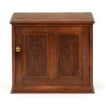 A carved oak cupboard, the interior fitted with drawers and pigeon holes, 52cm h; 29 x 56cm