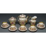 A French porcelain tea service, c1860, painted with puce flowers amidst richly gilt scrolling