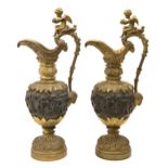 A pair of patinated bronze ornamental ewers, late 19th c, cast with bacchanalian revelry, the