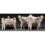 Two Sitzendorf floral encrusted baskets, late 19th century, on three or four cherub figural feet,