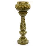 A green majolica jardiniere and pedestal, c1910, moulded with flowers and leaves, 121cm high