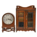 A German oak mantel clock, c1925, with silvered dial and gong striking movement, in arched case,