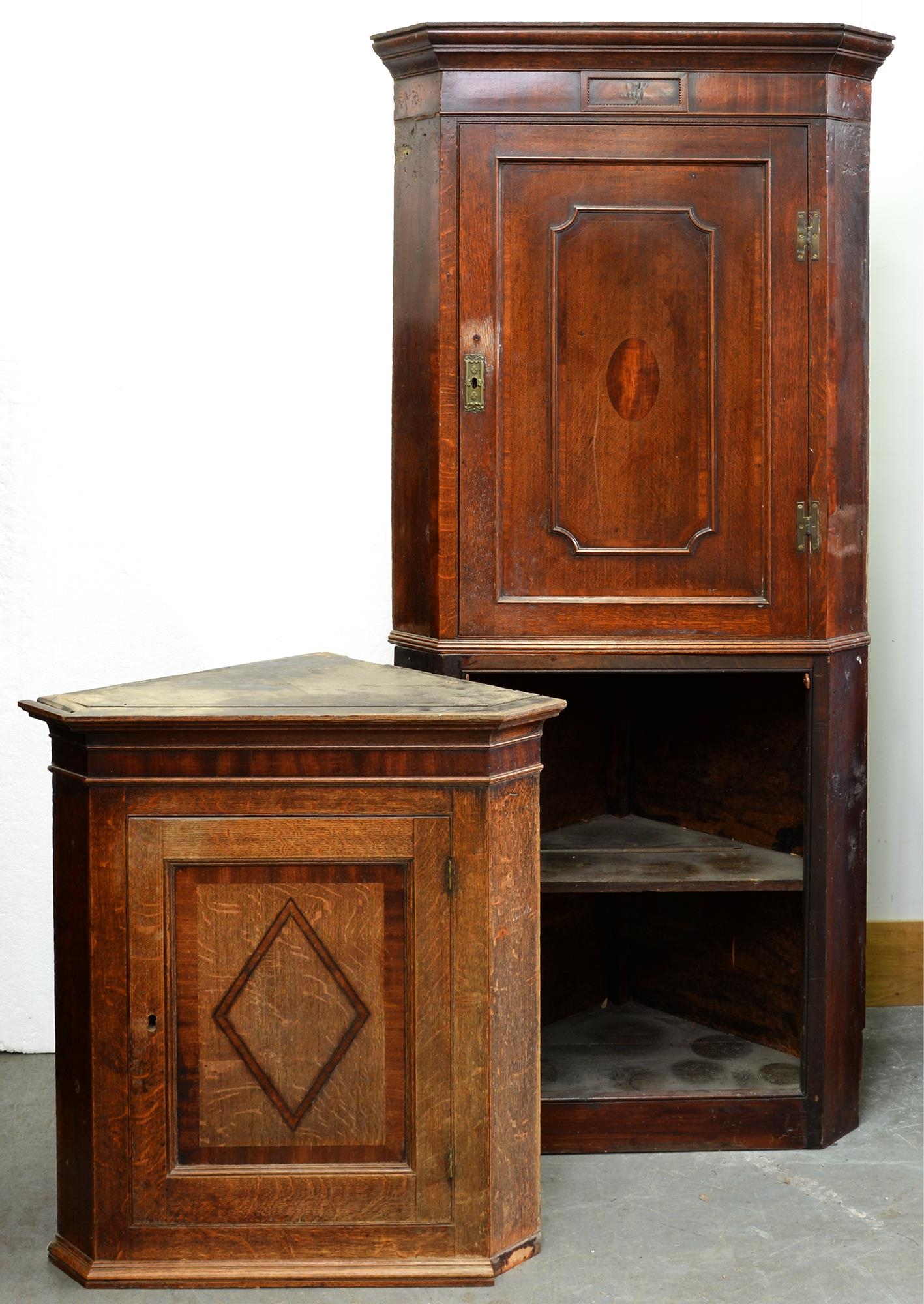 Two George III oak corner cabinets, one on associated base Condition evident from image