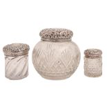 Three Victorian cut glass toilet jars with embossed silver covers, 12cm h and smaller, by various