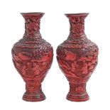 A pair of Chinese cinnabar lacquer vases, late 19th/early 20th c, carved with an immortal and others