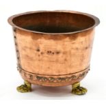 A riveted copper vat, on three cast brass lion's paw feet, 41cm h, 54cm diam Coated in an old now