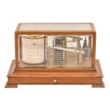 An Edwardian oak barograph, with lacquered brass mechanism, the cover with bevelled glass lights,