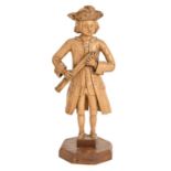 An 18th c softwood carving of a musician, probably German or Austrian, holding a bassoon, wearing