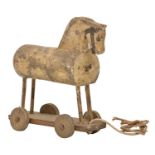 Folk Art. A 19th c softwood child's horse on wheels toy, jointed construction, traces of