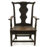 A George III oak elbow chair, profusely carved and stained in the late 19th c Slightly unstable