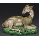 A Staffordshire earthenware model of a recumbent deer, Wood family, c1780-1800, decorated in