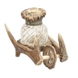 A German antler wheelbarrow novelty inkwell, with spirally lobe-moulded glass well, original, 13cm l