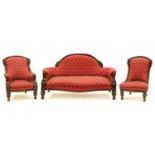 A Victorian carved mahogany suite, the settee, arm and nursing chairs with arched back rail and