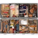 A metal cabinet with eight graduated drawers, enclosing miscellaneous tools, including wooden-hafted