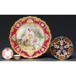 A German porcelain plate, c1900, decorated in Vienna style with Cupid and a maiden on a terrace,
