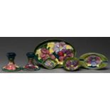 A pair of Moorcroft Clematis candlesticks, three dishes and an ashtray, c1970, candlesticks 85cm