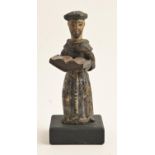 A European polychrome wood statuette of a monk, perhaps Spanish, with open gospel, on black