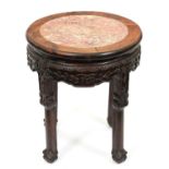 A Chinese rosewood stand, c1900, with pink stone centred top and carved apron, 48cm h; 42cm diam,