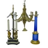A brass mounted blue foiled glass table lamp, an Empire style bronzed metal three lion lamp and a