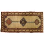 A Persian medallion rug, first-half 20th c, ochre ground with geometric motifs and stylized foliage,