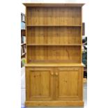 A pine kitchen dresser, 20th/21st c, moulded outswept cornice above two shelves, cupboard base,