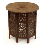 A Middle Eastern brass inlaid and carved wood table, on folding base, early 20th c, 62cm h; 60cm