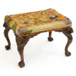 A walnut dressing stool, early 20th c, the cabriole legs carved with head and acanthus, on claw