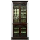 A mahogany bookcase, early 20th c, the upper part with pear drop frieze and enclosed by a pair of