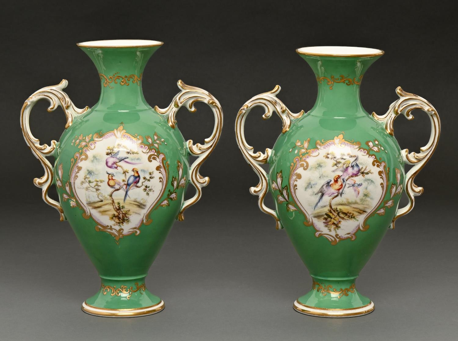 A pair of Coalport apple green ground vases, c1860, with gilt rococo handles, painted with exotic