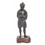A Japanese bronze statuette of a man, Tokyo School, Meiji period, holding a pipe, black patina, 32cm