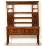 An oak dresser, early 20th c, the rack with two spice cupboards with geometrically panelled doors,