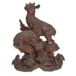 A Swiss carved limewood sculpture of two mountain deer, 19th / 20th c, on rocks and vegetation, 54cm