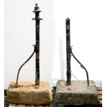 A pair of Victorian cast iron gateposts with wrought iron strut, set in stone bases, 151cm h overall