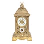 A French cast brass mantel clock, late 19th c, with aneroid barometer and primrose enamel dial, in