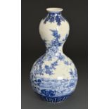 A Japanese blue and white double gourd vase, 20th c, painted with a continuous landscape, 25.5cm h