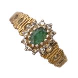 An emerald and diamond cluster ring, in gold, with textured shoulders, marked 18ct, 5.2g, size F