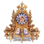 A French gilt lacquered brass mantel clock, 19th c, in Troubadour style, inset with porcelain