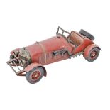 A red painted tinplate model racing car based on a Mercedes Benz, 1920's style, 26.5cm l Paint