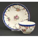 A Worcester fluted teacup and saucer, c1780, painted with bouquets and swags in blue and gilt