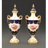 A pair of Coalport vases and covers, early 20th c, of shield shape, painted by F Howard, both